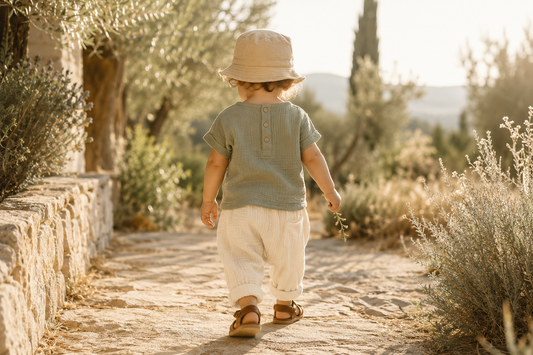 Enfant en tenue bohème complète en gaze de coton dans un jardin méditerranéen